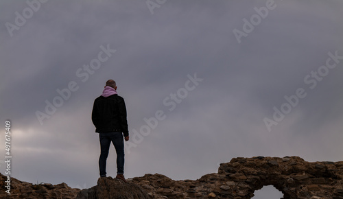 Rear view of adult man standing on ruin wall. Almeria, Spain