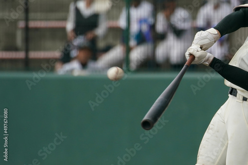 野球の試合中にピッチャーの投げた球をインパクトしてホームランにする左バッター photo