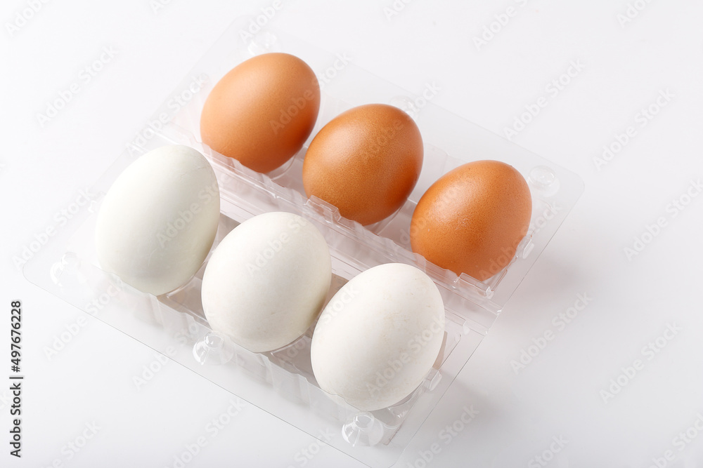 3 Duck eggs (White color) and 3 chicken eggs (Brown color) arranged in plastic packaging boxes for sale. 3 Duck eggs (White color) and 3 chicken eggs (Brown color) arranged in plastic packaging boxes for sale.