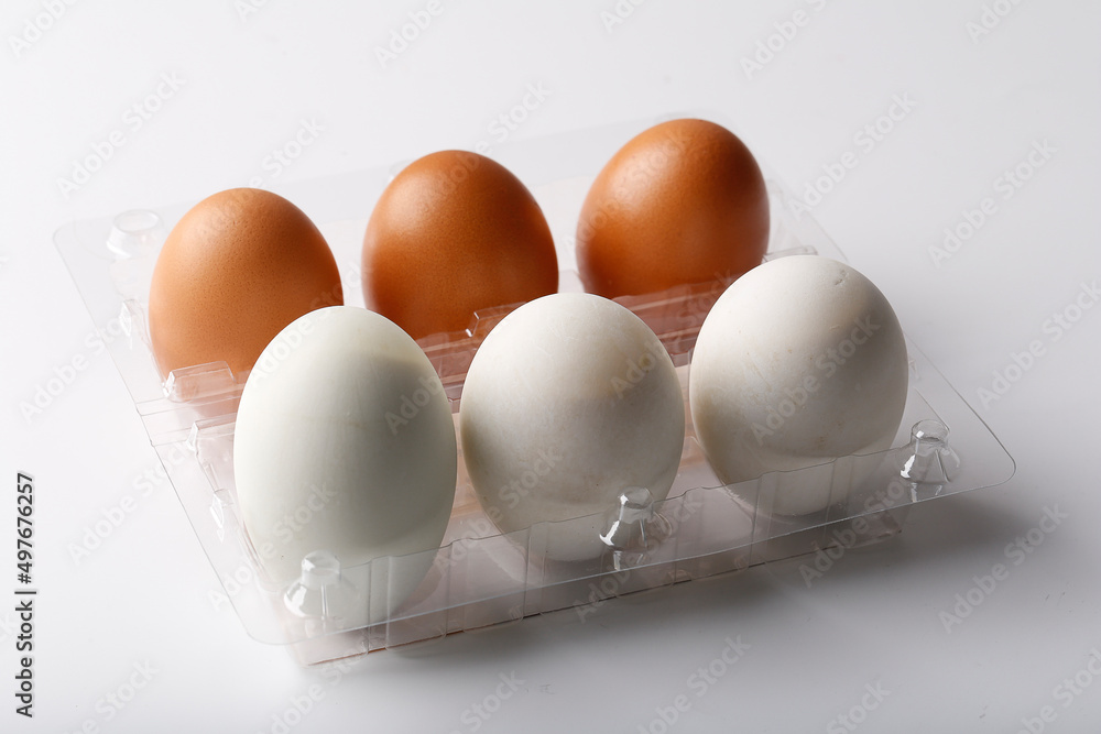 3 Duck eggs (White color) and 3 chicken eggs (Brown color) arranged in plastic packaging boxes for sale. 3 Duck eggs (White color) and 3 chicken eggs (Brown color) arranged in plastic packaging boxes for sale.