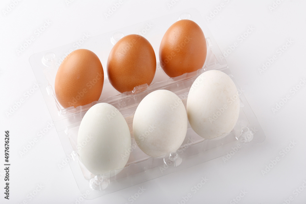 3 Duck eggs (White color) and 3 chicken eggs (Brown color) arranged in plastic packaging boxes for sale. 3 Duck eggs (White color) and 3 chicken eggs (Brown color) arranged in plastic packaging boxes for sale.