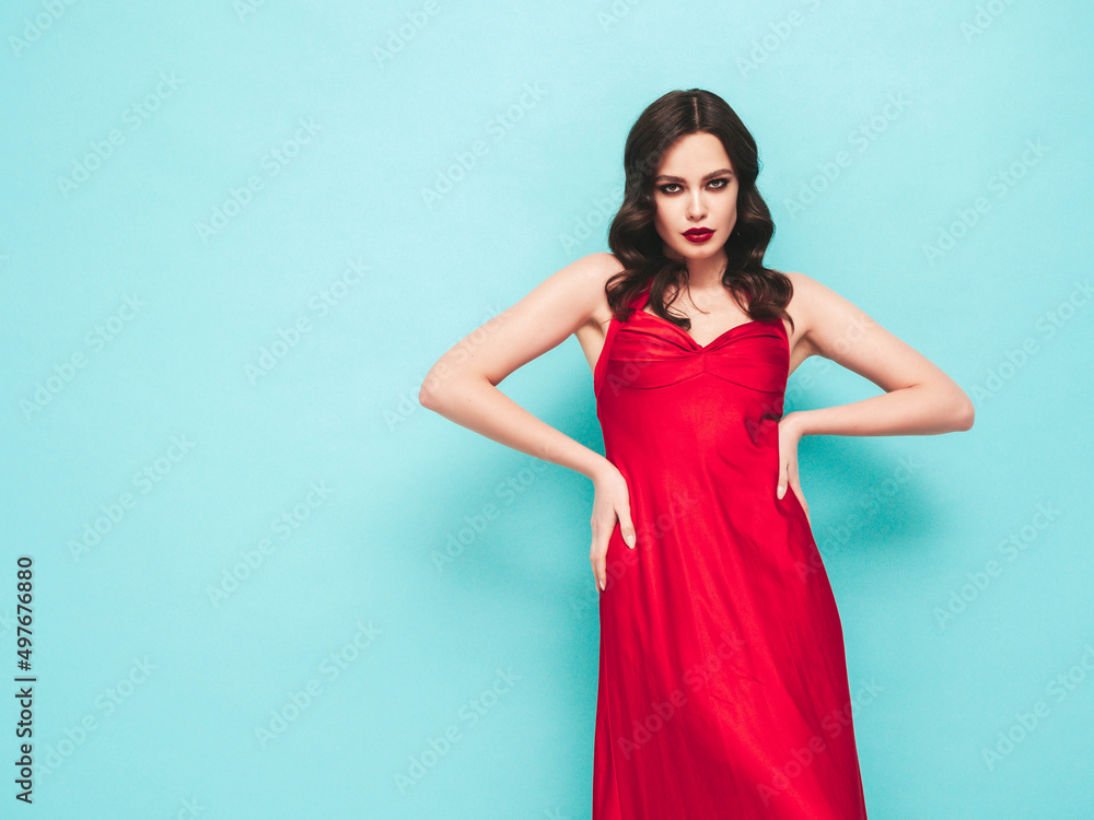 Beauty portrait of young brunette woman with evening makeup and perfect clean skin. Sexy model with curly hair posing in studio. With red bright natural lips.In red dress Beauty portrait of young brunette woman with evening makeup and perfect clean skin. Sexy model with curly hair posing in studio. With red bright natural lips.In red dress