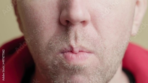 White man eats chips. The face of an unshaven man eating potato chips. Close-up, front view