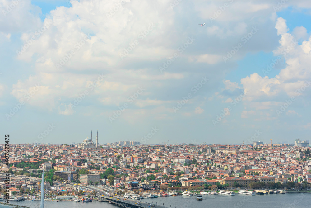 View of Istanbul on a sunny summer day with a bright blue sky with white clouds and a flying plane. Travel concept
