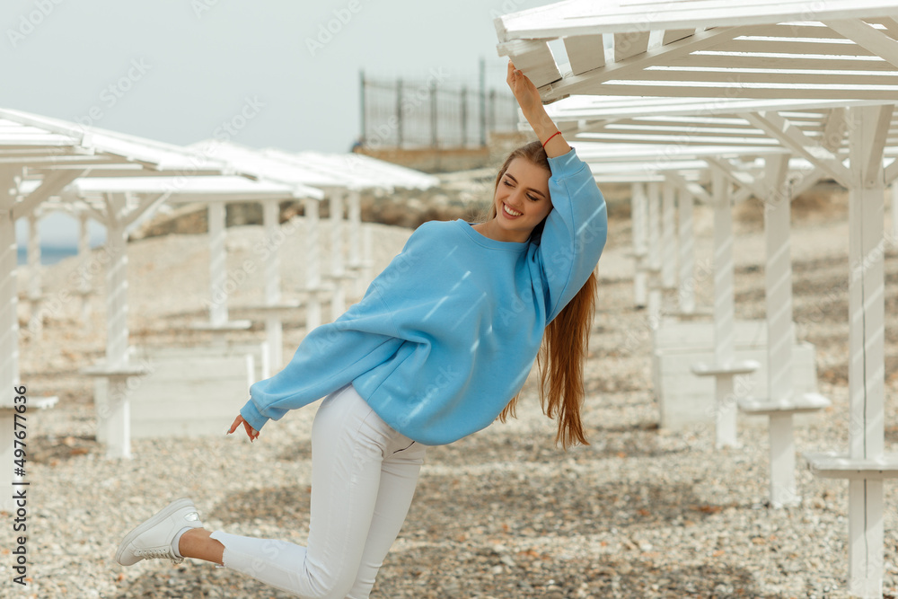Young beautiful woman with long hair in a blue sweatshirt Young beautiful woman with long hair in a blue sweatshirt