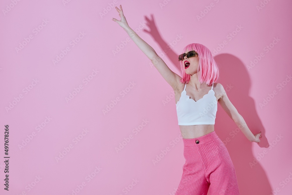 Beautiful fashionable girl in pink pants sunglasses posing pink background unaltered