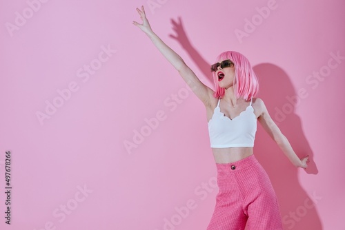 Beautiful fashionable girl in pink pants sunglasses posing pink background unaltered