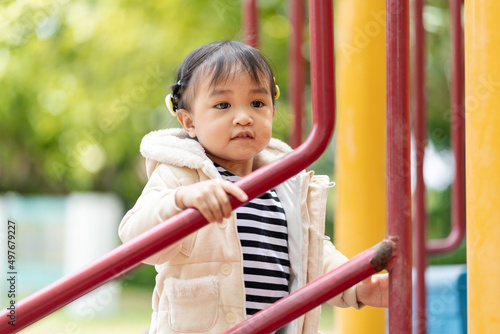 Adorable little girl having fun in the outdoor playground.