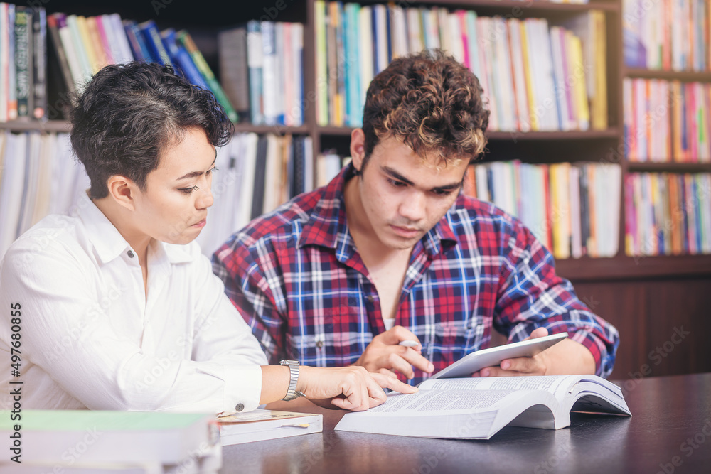 Asian college students sitting reading, studying, examining, Tutor books with friends. People learning education concept Asian college students sitting reading, studying, examining, Tutor books with friends. People learning education concept