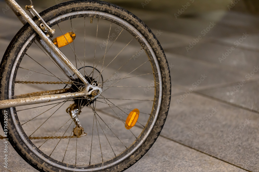 Old and dirty mountain bike used for commuting parked in the bike rack at city center. Picture taken in the evening, poor light coming form the street lights. Old and dirty mountain bike used for commuting parked in the bike rack at city center. Picture taken in the evening, poor light coming form the street lights.