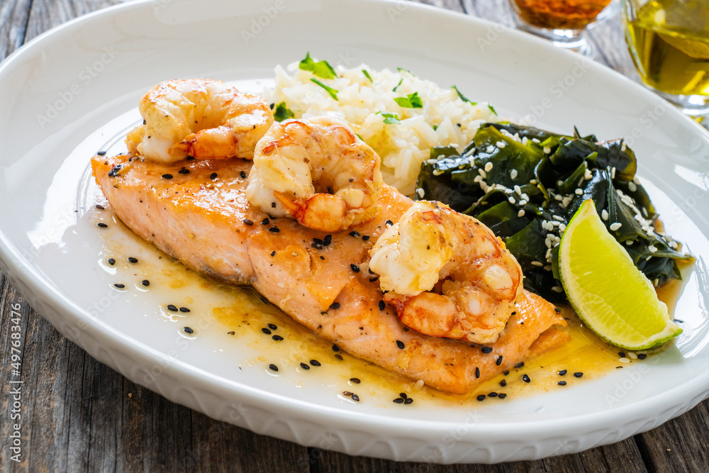 Fried salmon steak with prawns, white rice and spinach on wooden table
Fried salmon steak with prawns, white rice and spinach on wooden table