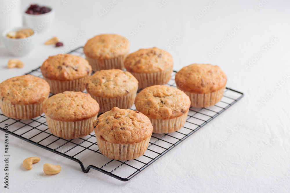Vanilla fresh baked muffins on a white table with nuts and berries Vanilla fresh baked muffins on a white table with nuts and berries