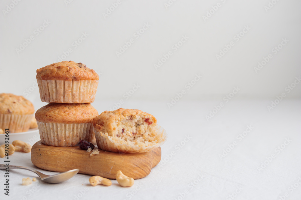 Muffins in a wooden plate on a white table Muffins in a wooden plate on a white table
