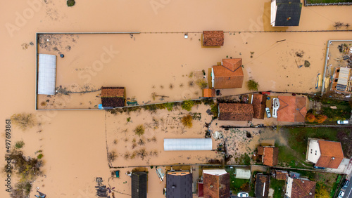 Aerial drone view of torrential rain causes flash floods in residential areas. Houses and roads surrounded by water. Climate change. Heavy rainfall consequences. 
