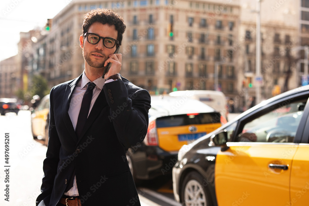 Handsome businessman talking to the phone. Young elegance man outdoors..