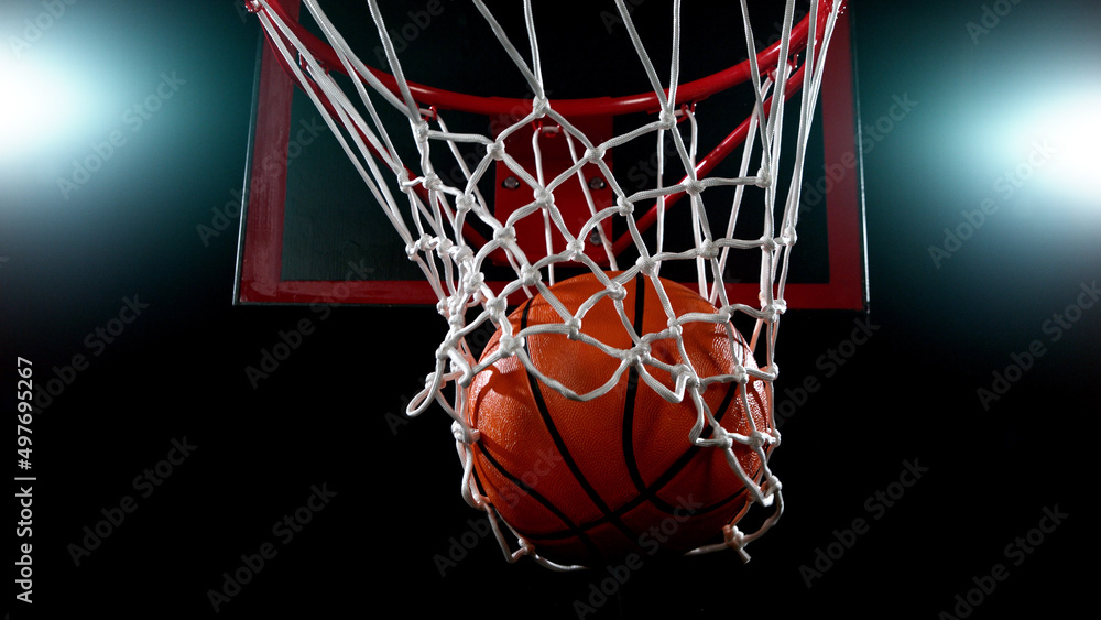 Basketball going through the basket on black backgorund