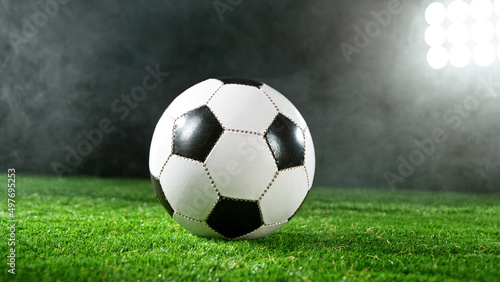 Soccer ball placed on grass, dark background. © Jag_cz