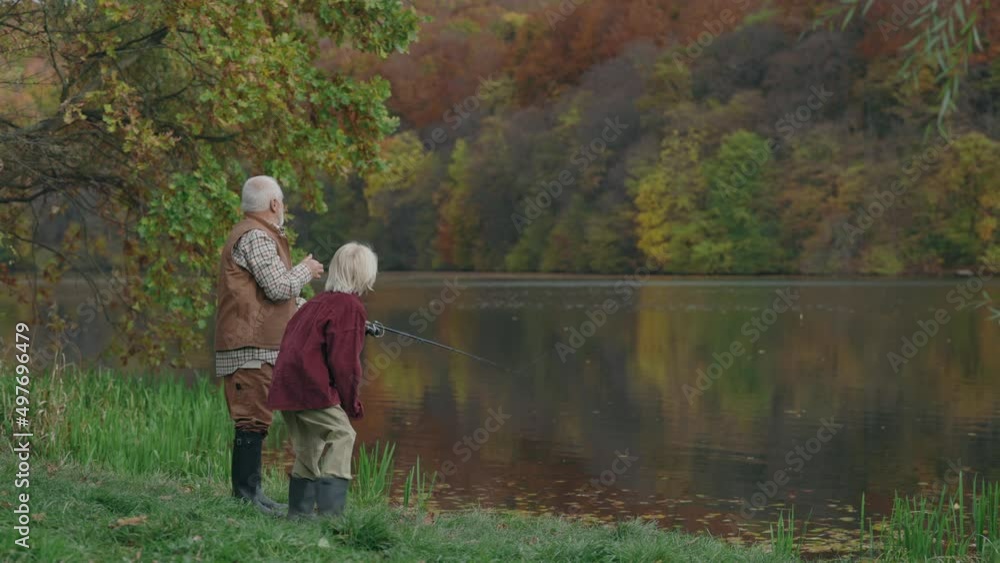 Senior man fishing with his grandson on local lake Senior man fishing with his grandson on local lake