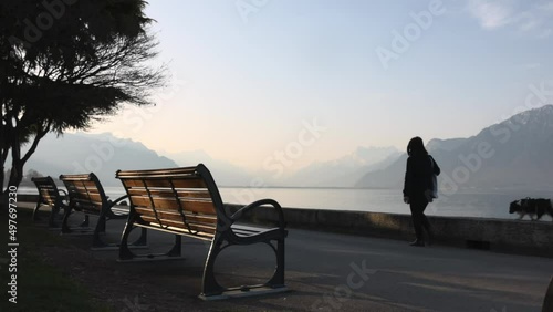Woman walking with dog on lake Geneva embankment (ID: 497697230)