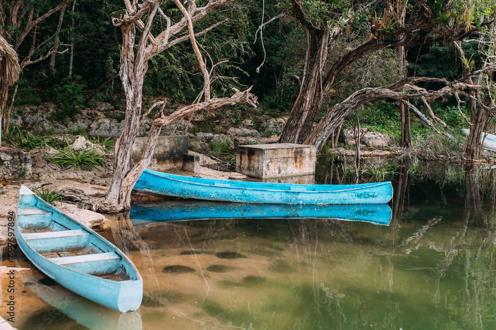 Fototapeta premium Hellblaues Kanu im Wasser in wunderschöner Natur in Mexiko Yucatan