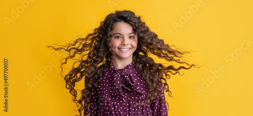 Konstfotografi cheerful girl with long brunette curly hair on yellow background