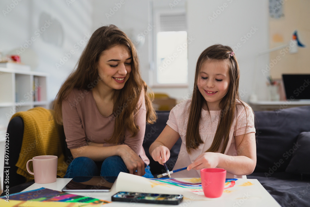 mother and daughter painting picture together mother and daughter painting picture together