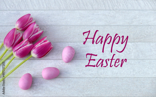 Easter card: pink tulips and Easter eggs with the text Happy Easter.