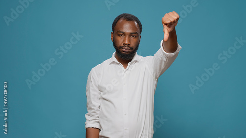 Konstfotografi Negative person doing thumbs down gesture in studio, disagreeing with new solution