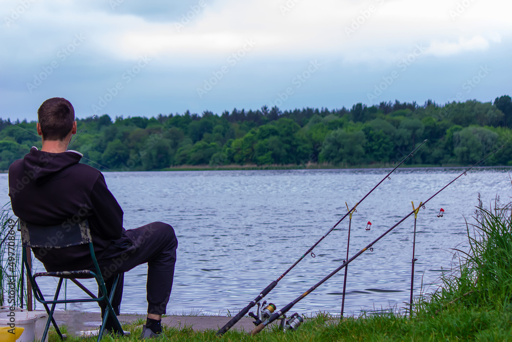 Close-up of a fishing rod wheel, a man is fishing. Nature