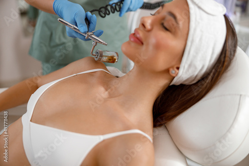 Professional female cosmetologist perform a hydrafacial procedure in modern a cosmetology clinic photo