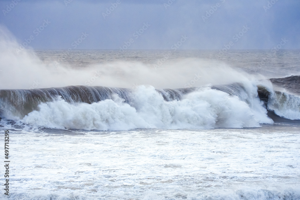 Big waves crashing on the sea with greenish blue color during a cloudy day Big waves crashing on the sea with greenish blue color during a cloudy day