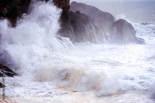 Big waves crashing on the rocks during a storm