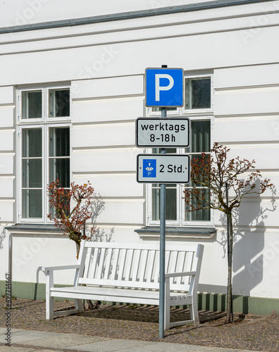  Verkehrszeichen für zeitlich begrenzten Parkdauer vor weisser Hauswand photo