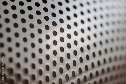 Metal fragment, chrome-plated surface with perforations in the form of round holes, metal colander. Close-up © AndreyZayats