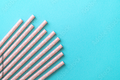 Biodegradable paper straw set on blue table background.