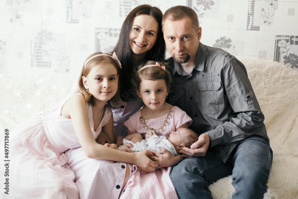 portrait of older sisters hugging their newborn brother . portrait of older sisters hugging their newborn brother .
