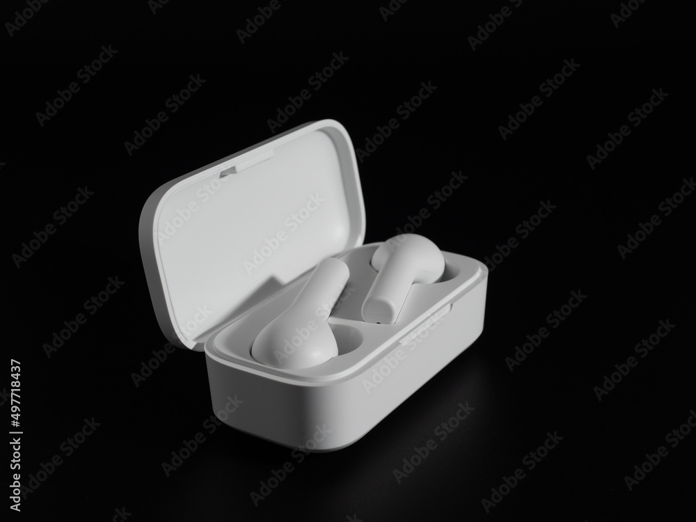 White wireless headphones on a black background. White wireless headphones on a black background.