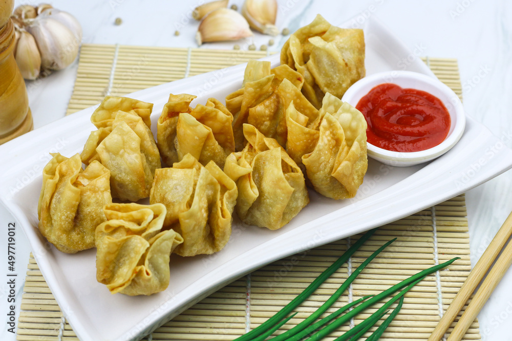 Siomay Goreng or Pangsit Goreng, Indonesian popular street food, made from fish and shrimp wrapped with dumpling wrapper, deep fried, served with chili sauce or peanut sauce. Selective focus. Siomay Goreng or Pangsit Goreng, Indonesian popular street food, made from fish and shrimp wrapped with dumpling wrapper, deep fried, served with chili sauce or peanut sauce. Selective focus.