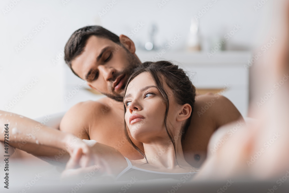 Obraz premium Pretty brunette woman taking bath with boyfriend at home.