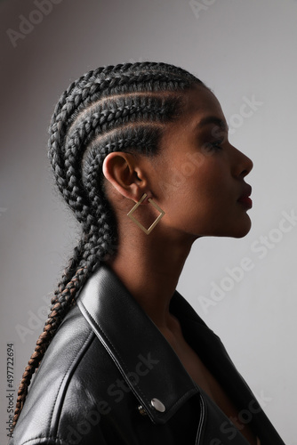 Print op canvas Vertical portrait of African young woman with braids posing on white wall