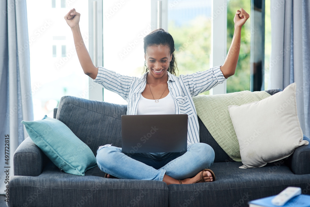 The fast wifi is working in her favor. Shot of a young woman cheering while using a laptop at home. The fast wifi is working in her favor. Shot of a young woman cheering while using a laptop at home.