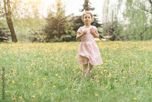 girl runs through dandelions in the park