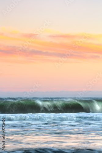 Motion blur in crashing waves under a beautifully colorful sunset sky. Long Island  New York
