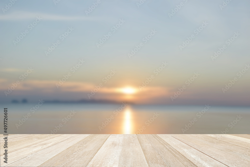 Empty top wooden table on soft focus blurred beautiful sunset at sea for background
