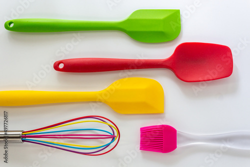 Spatulas ,whisk and cooking brush made from silicone in various color lay on white background