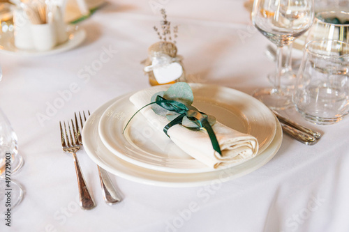 table setting elements in the restaurant  white tablecloth  white plate  white napkin
