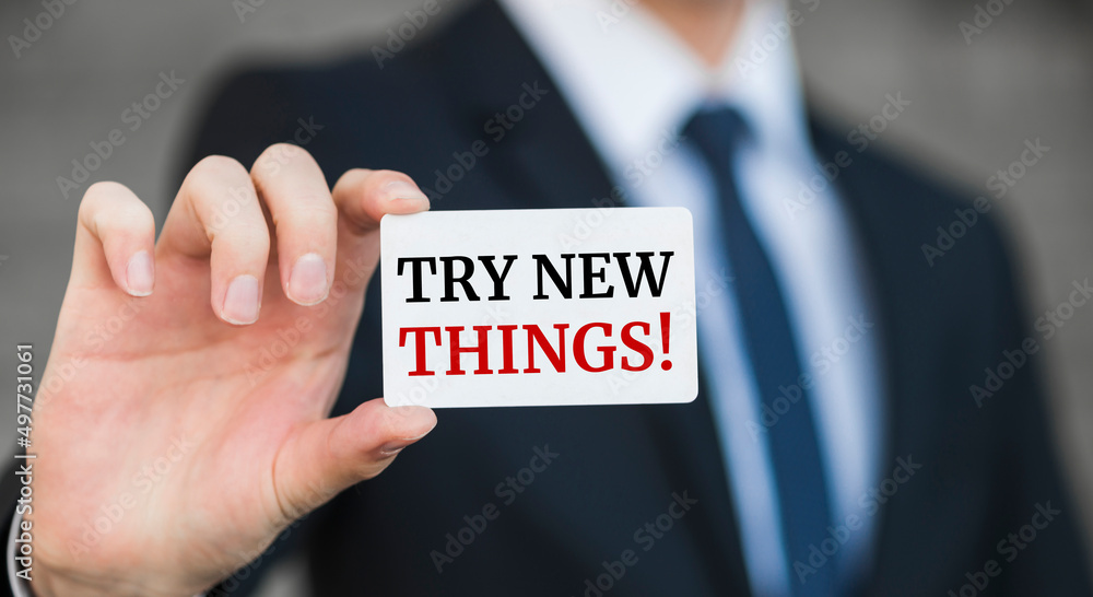 Businessman presenting 'Try new things' word on white card Businessman presenting 'Try new things' word on white card