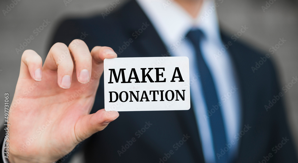 Businessman presenting 'Make a donation' word on white card Businessman presenting 'Make a donation' word on white card