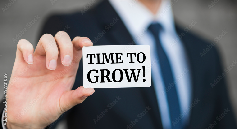Businessman presenting 'Time to grow' word on white card Businessman presenting 'Time to grow' word on white card