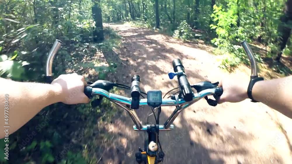 Сyclist rides on a forest path, first person perspective view POV. Mountain biking in summer green woods. Sport and healthy lifestyle. Bike rides. Сyclist rides on a forest path, first person perspective view POV. Mountain biking in summer green woods. Sport and healthy lifestyle. Bike rides.